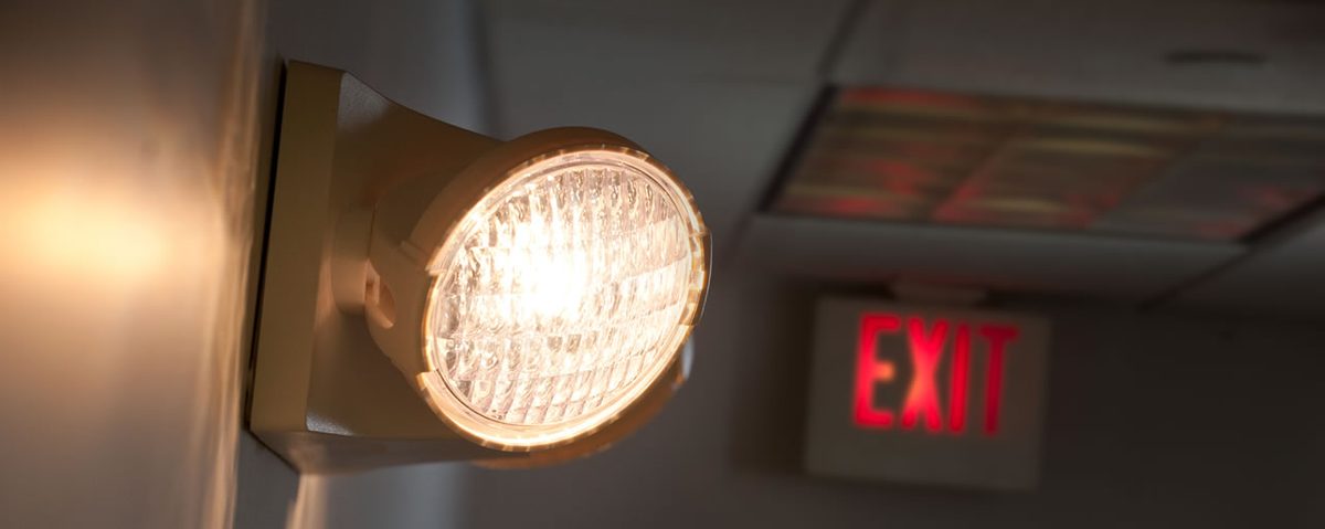 An emergency light and exit sign in a hallway